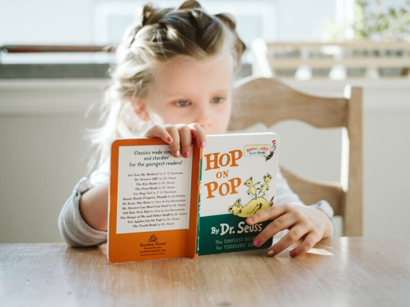 Little girl reading hop on pop by dr suess