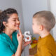 Parent teaching child to pronounce the letter S