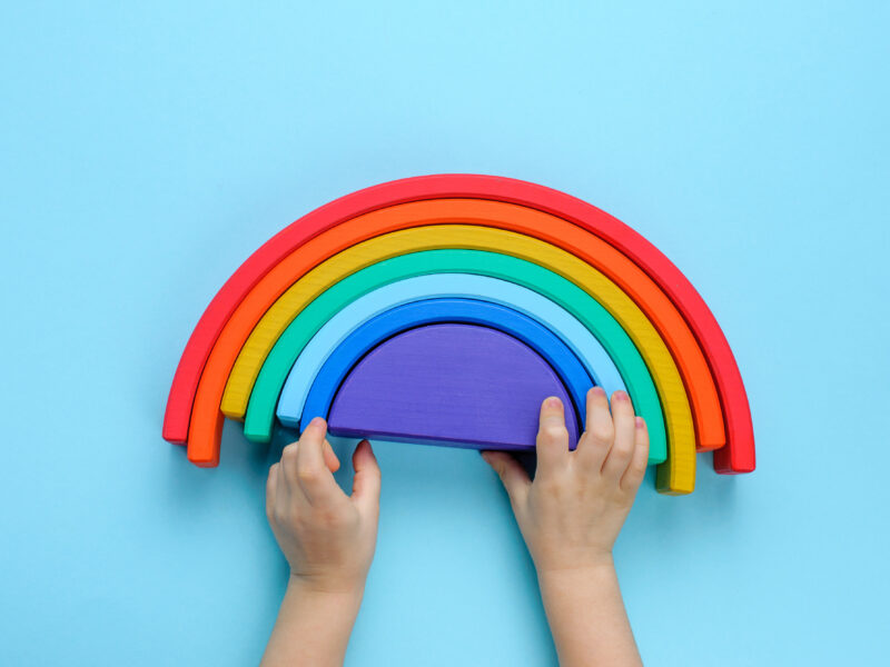 Child playing with a rainbow stacking toy