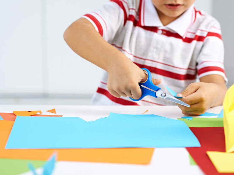 Little boy cutting construction paper