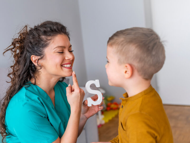 Woman teaching little boy to sound out the letter s