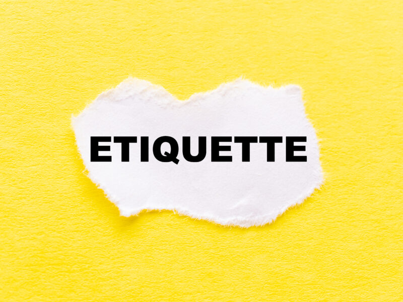 Etiquette written on a torn piece of paper on a yellow background